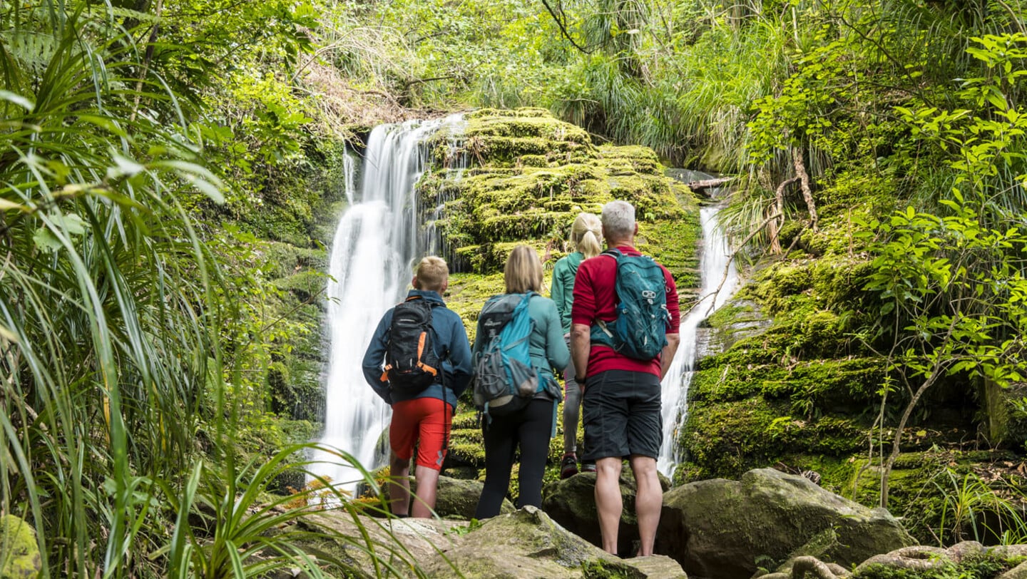 Family visiting the waterfall near Ship Cove in Queen Charlotte Sound